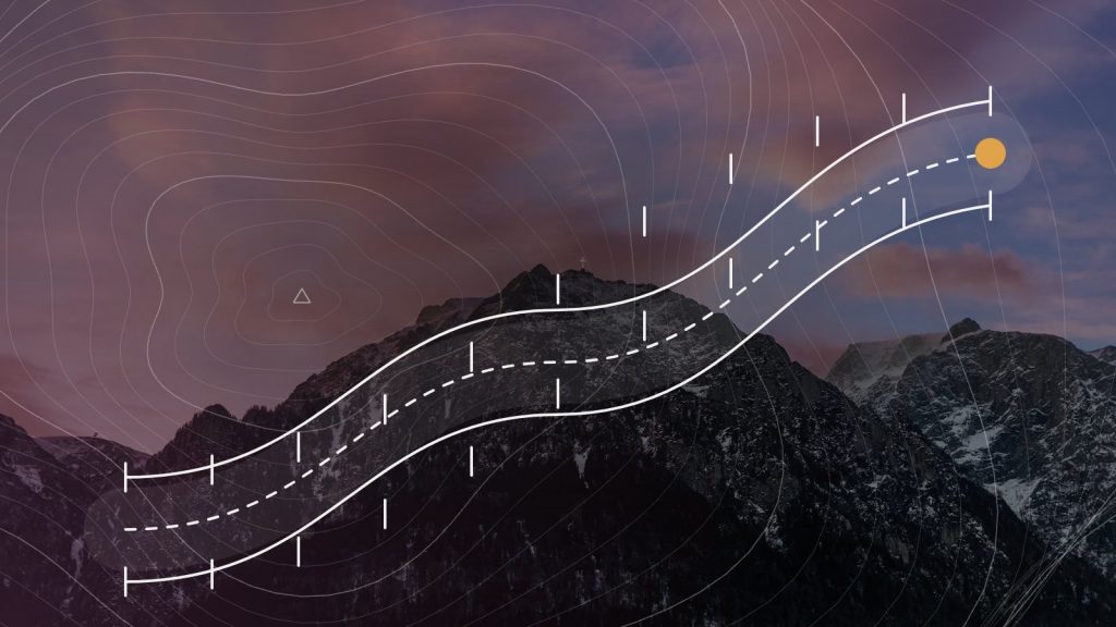 A ice axe planted in snow on a granite ledge above misty mountains, with contour lines and a marked route